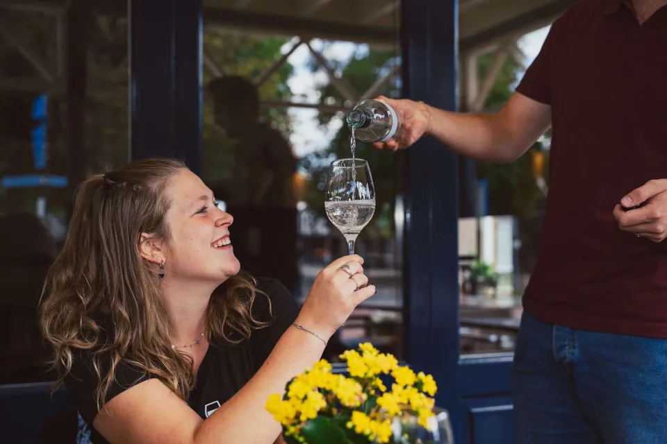 Er wordt een glas wijn ingeschonken tijdens een wijnproeverij bij Proeflokaal de Peel